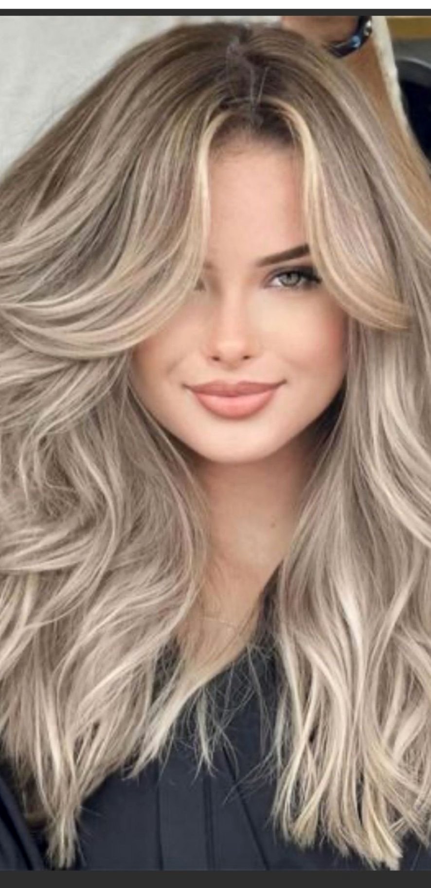 Long layered blonde balayage with soft waves and dimensional highlights